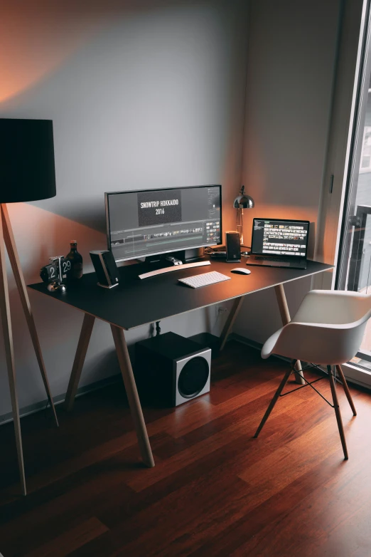 a computer on a table next to a chair