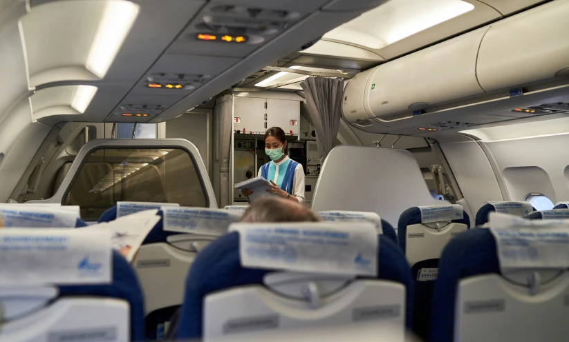 a man wearing a mask and glasses sits on a plane