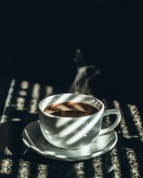 a cup and saucer that has a small amount of liquid on it