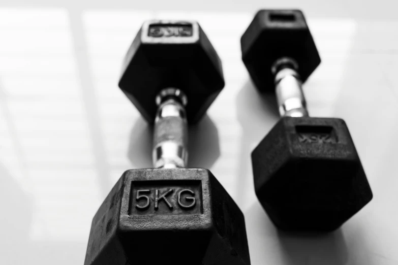 a black and white po of two black dumbbells