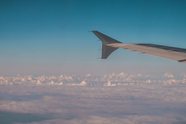 the wing and bottom of an airplane flying in the air