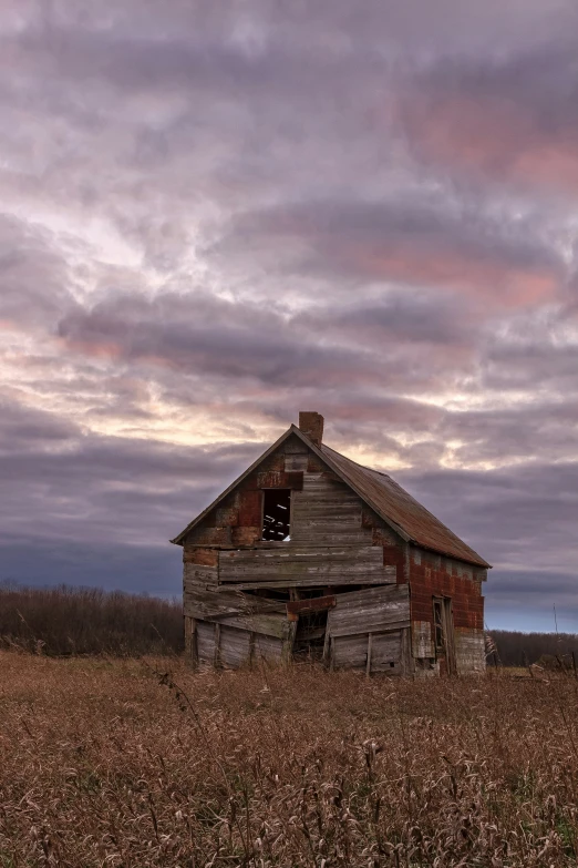 an old barn in a field of tall grass