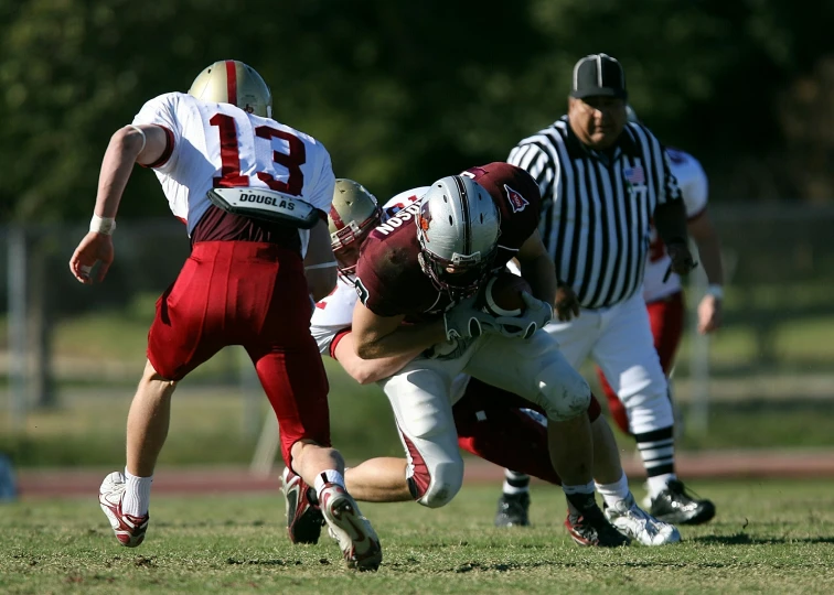 a football player is being tackled by a referee