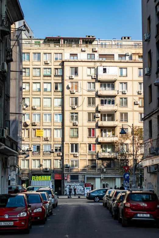 the city street with tall buildings and a row of parked cars