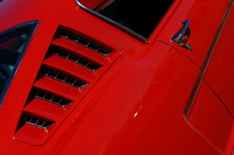 close up of the grills and windows on a red sports car