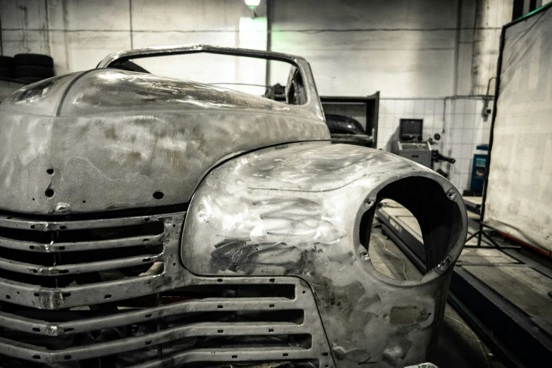 old gray car rusted to pieces in a garage