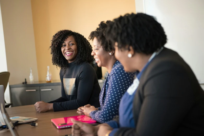 four smiling women sitting at a table together