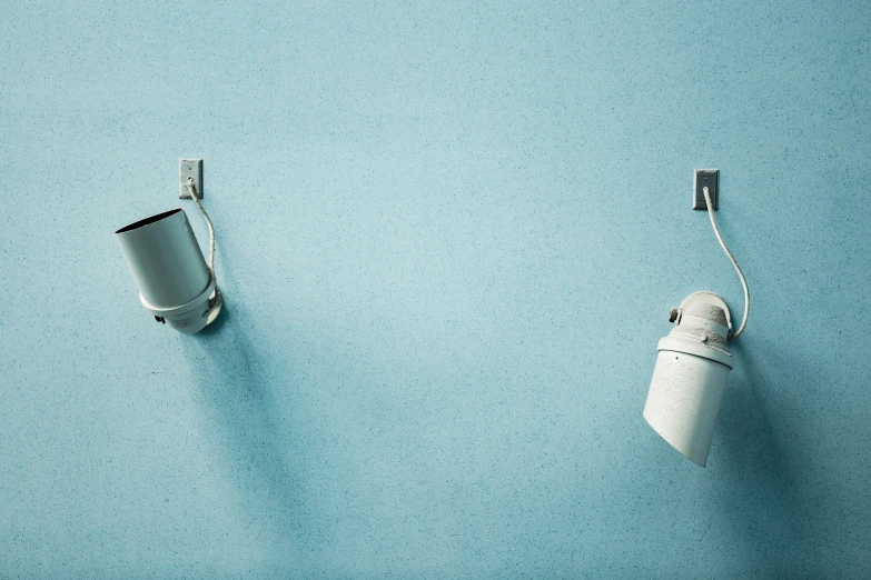 two toilet paper rolls mounted to a wall with the lights on