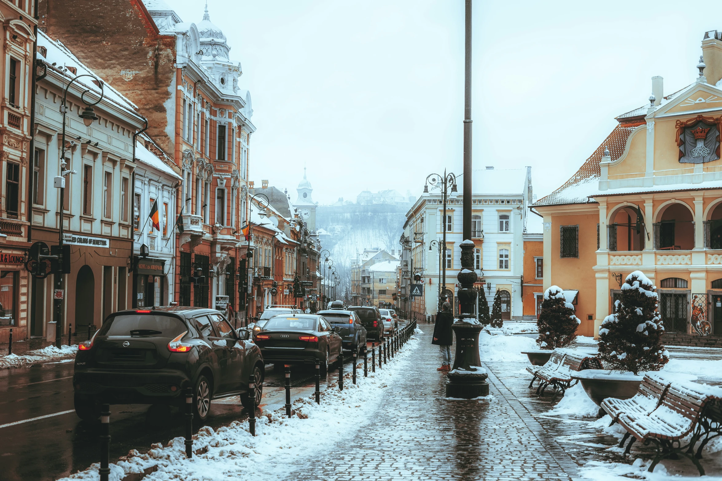 the snowy streets have snow and cars in it