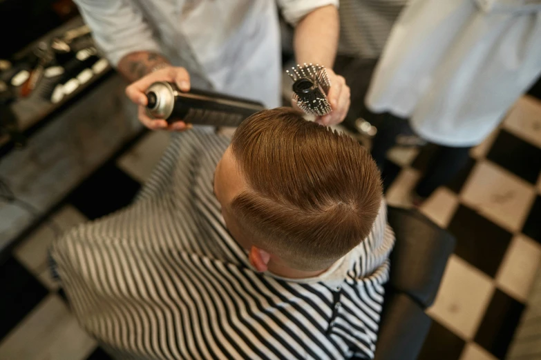 man doing hair  in checkered floor area at barbershop