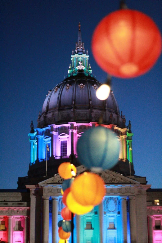 the lights are bright on the building's dome and are lit up with balloon decorations