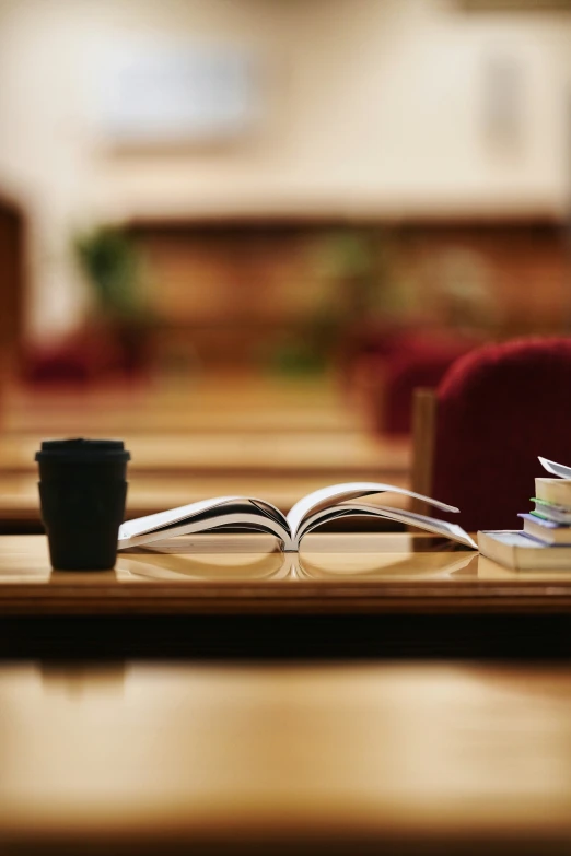 two open books are lying on a table next to a coffee cup