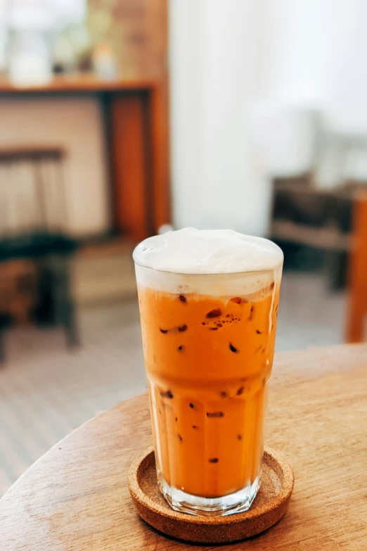 a drink in a glass sitting on top of a wooden table