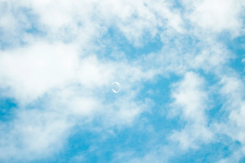 a bubble floating in the sky during a sunny day