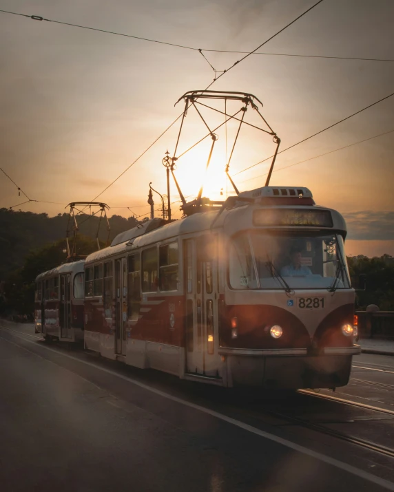 a red and white train pulling up to the end of a road