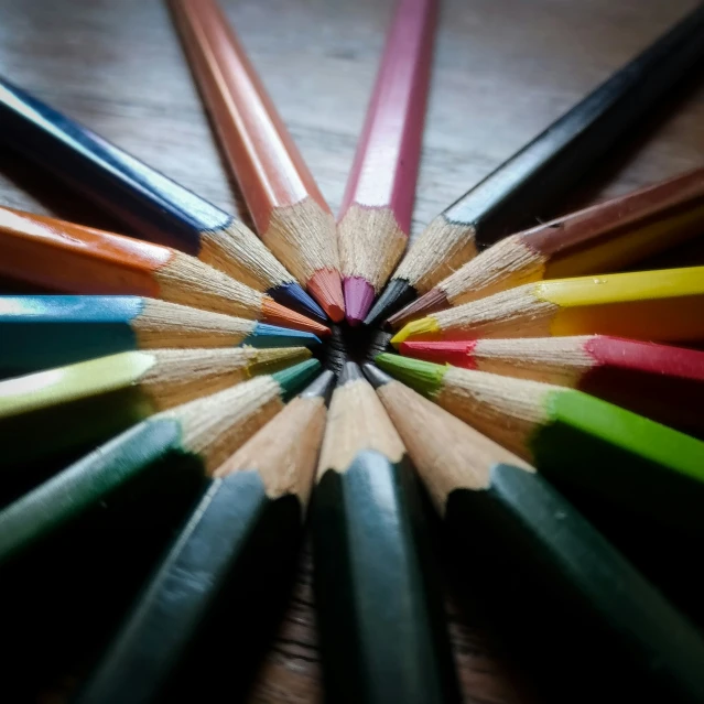 colored pencils arranged in a star with a wooden background