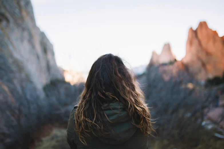 there is a woman walking on a trail outside