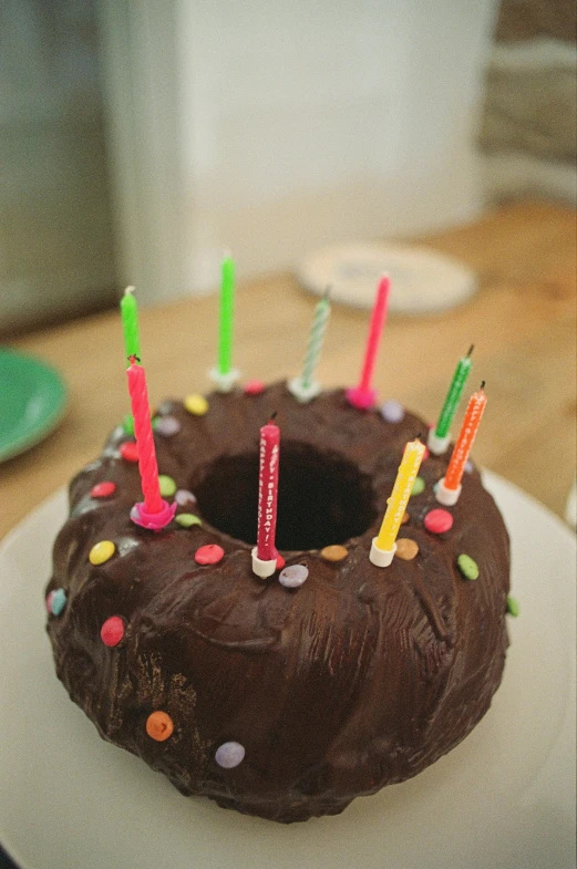 a cake with birthday candles on it sitting on a white plate