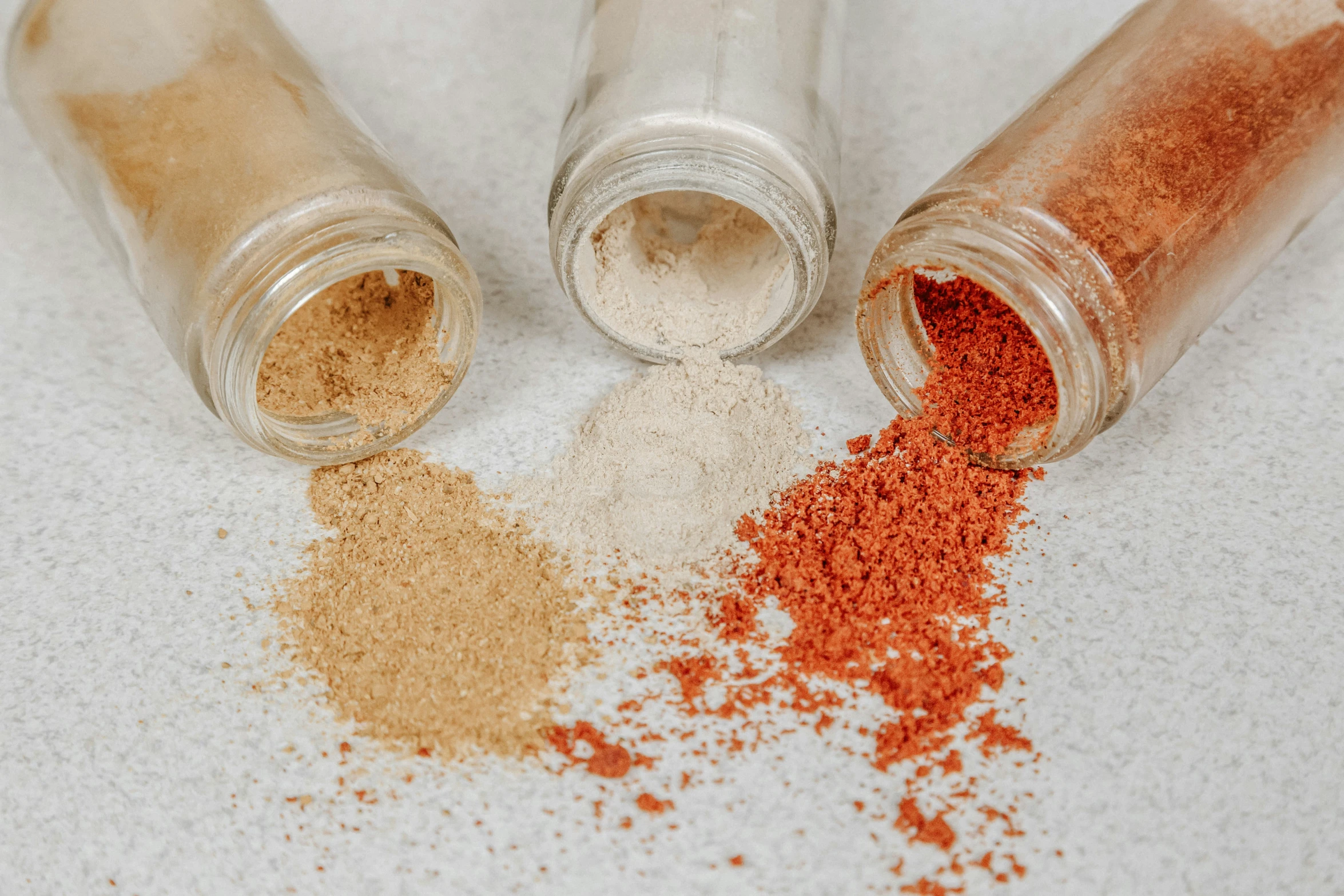 an assortment of spices sitting on top of a white counter