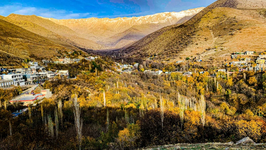 a valley is surrounded by mountains and houses