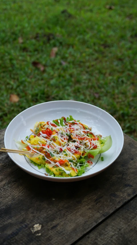 a plate with vegetables sitting on top of a wooden table