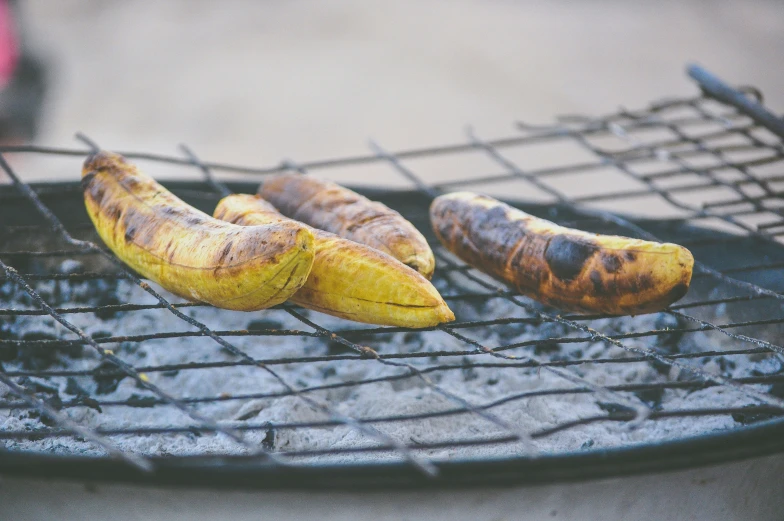 three bananas that are sitting on a grill