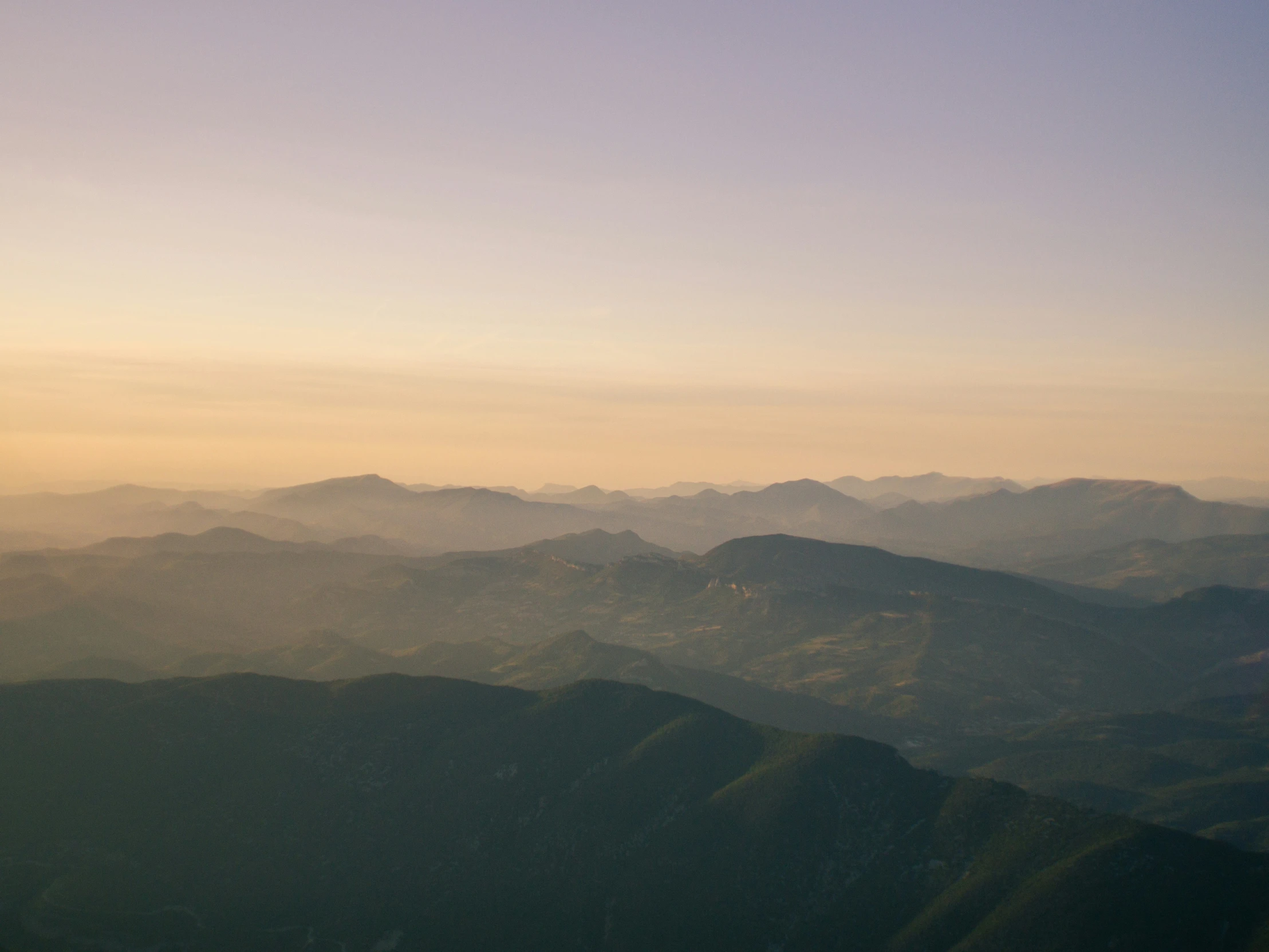 there are mountains in the distance from an airplane window