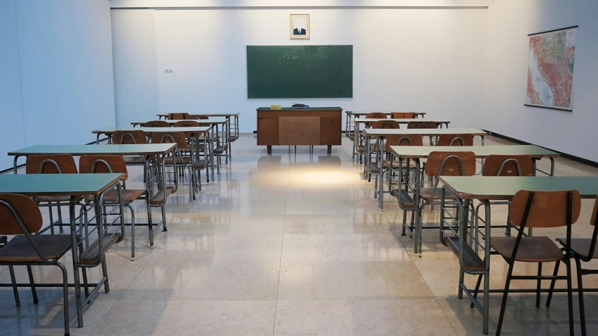 a large classroom with wooden desks and chalkboard