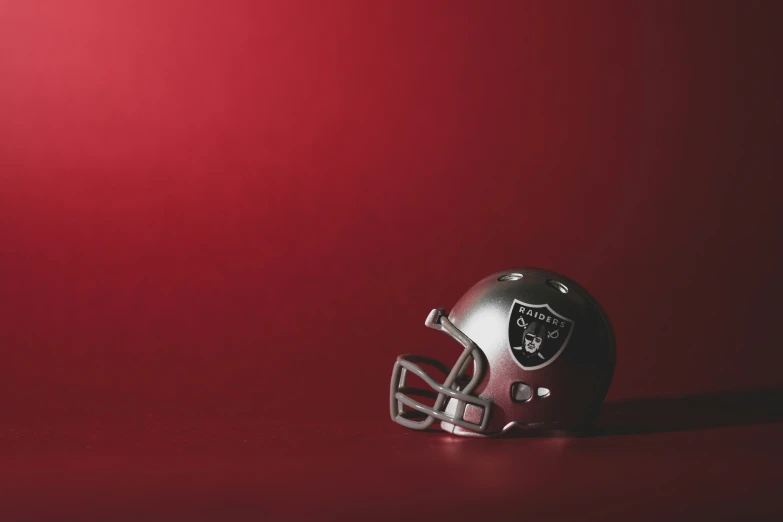 a black football helmet on top of a red background