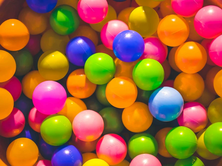 many different colored balloons inside a bucket