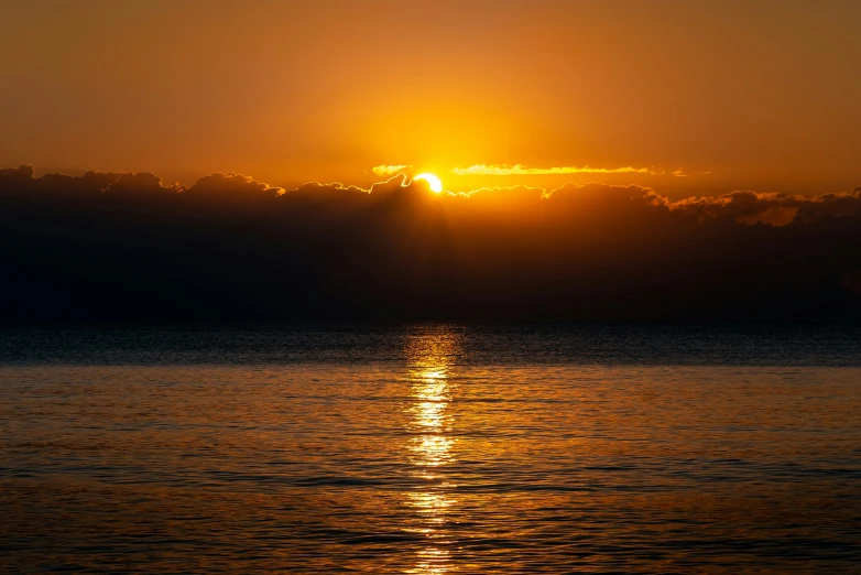 a view of the sun setting over water from a boat