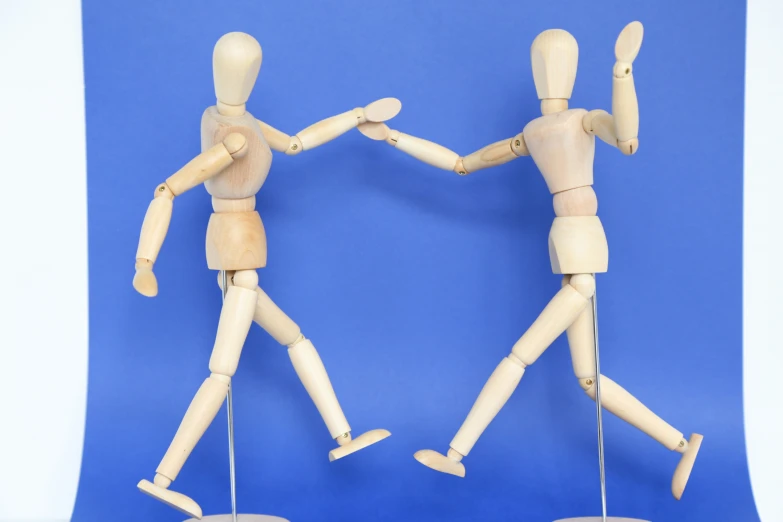 two wooden mannequins on top of wooden stools