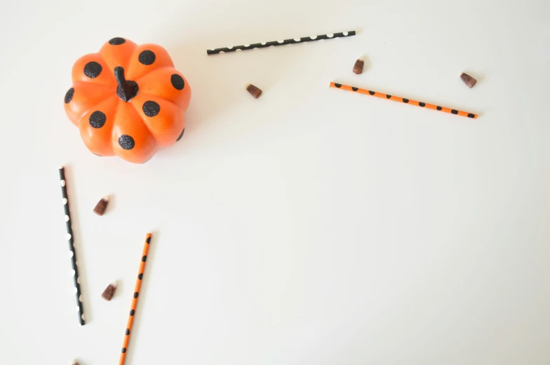 a orange decorative object that is laying on top of some string