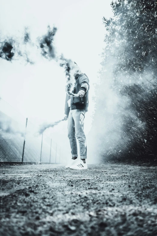 a man standing in the smoke as he blows