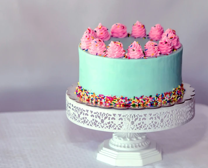 a multi colored cake with frosting and sprinkles