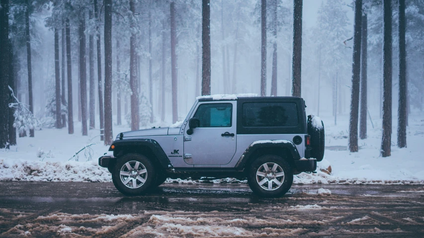 a jeep is driving on the road through the snow