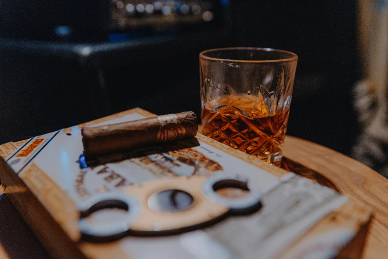 a glass and knife are on a wooden table