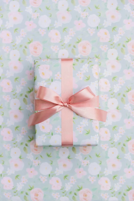 the wrapped present sits on the wall next to it's ribbon