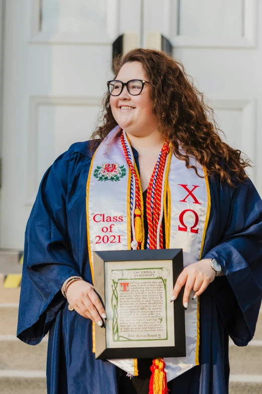 a woman wearing a graduation gown and holding an award