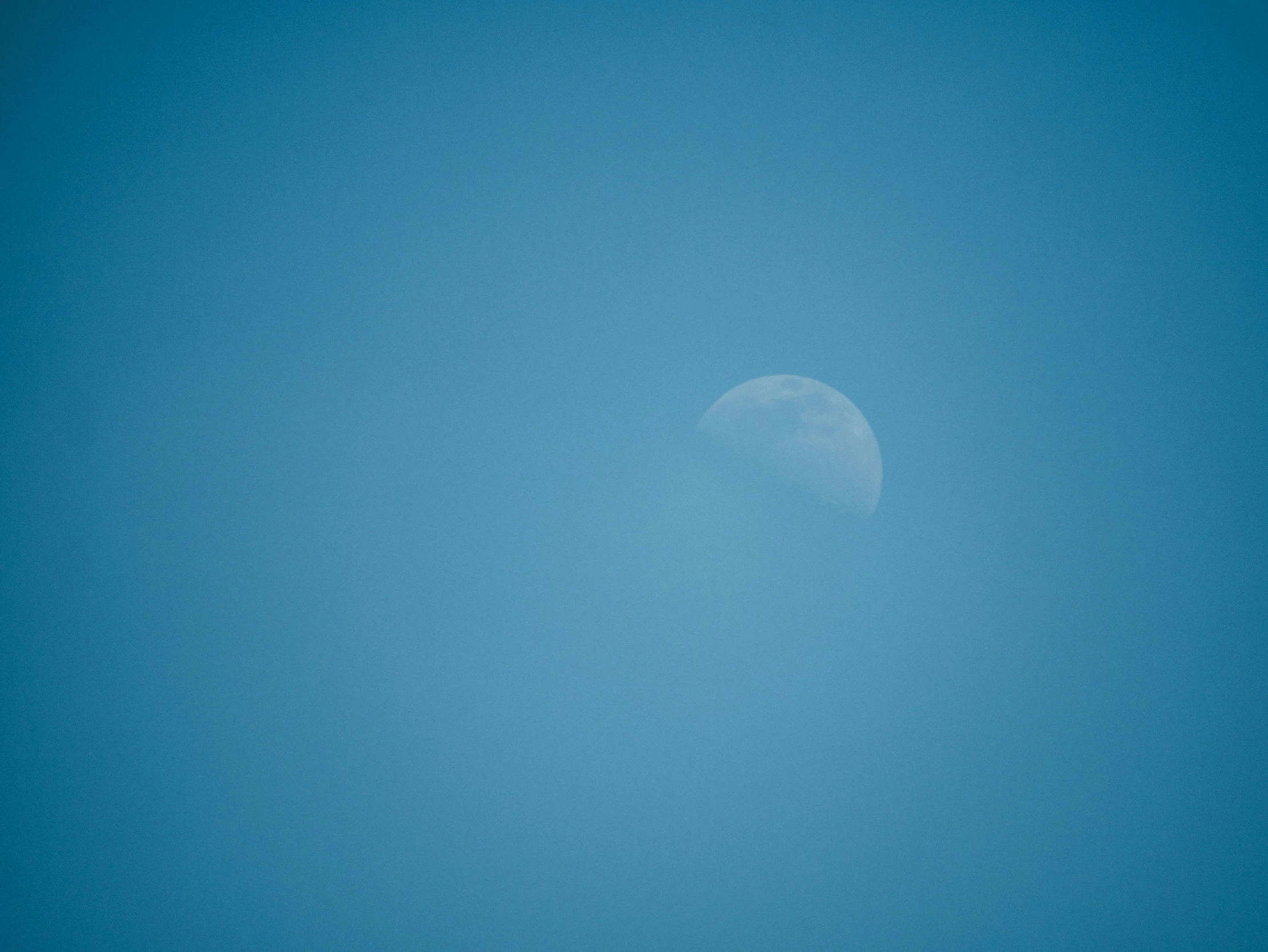 a jet airliner in flight flying across a bright blue sky