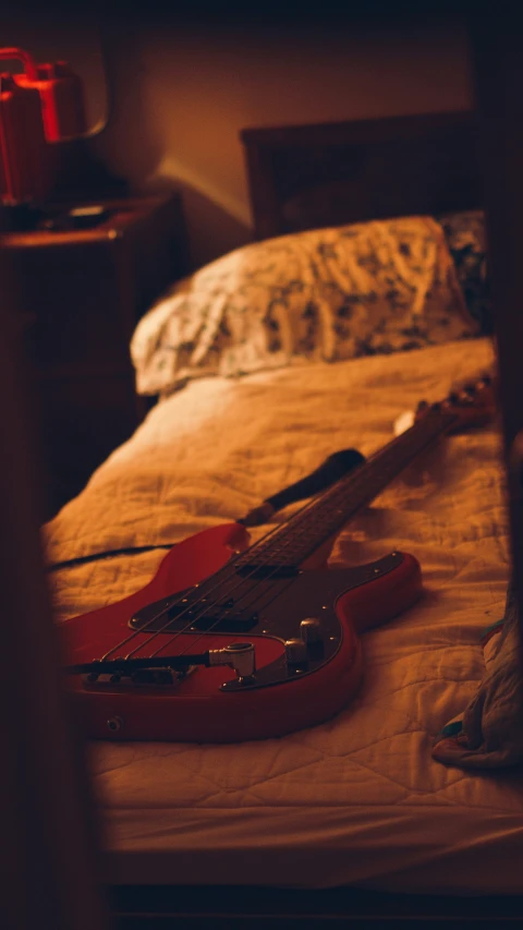 an electric guitar sitting on the bed with a flashlight