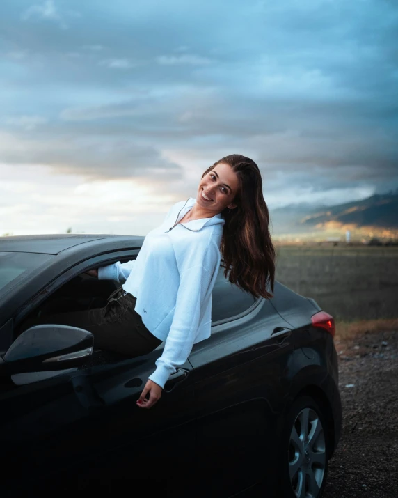 a woman with brown hair sitting in a car