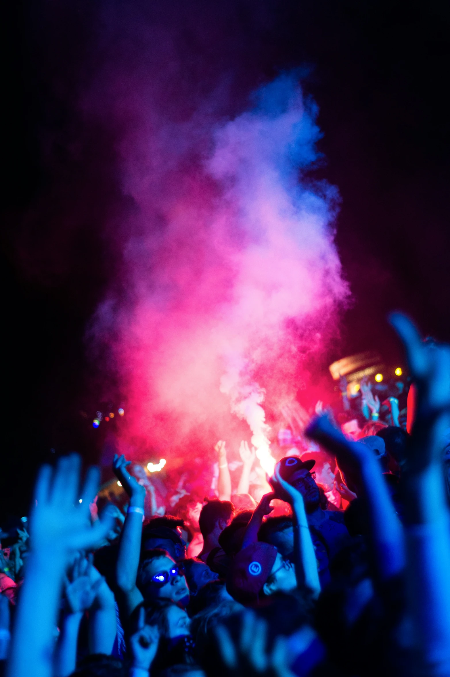 a crowd at a concert holding up their hands