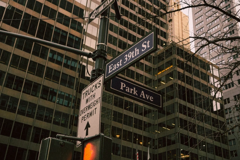 some street signs on a pole near some tall buildings