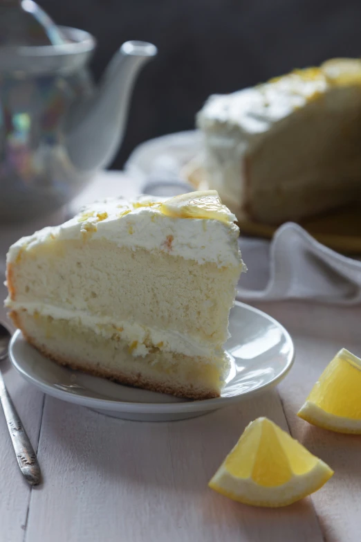 two slices of cake on plates with lemon wedges