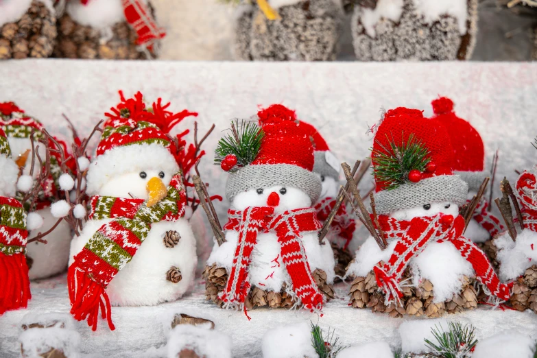 small christmas decorations with snowman's hats and scarfs are on display