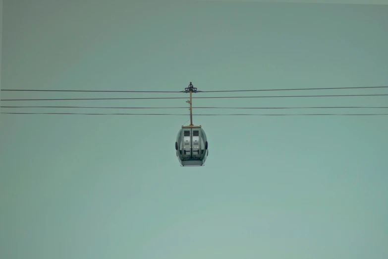 a gondola that is hanging from wires and some birds
