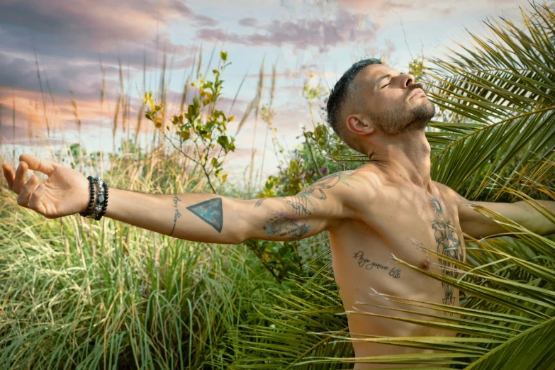 a man holding his arm in a grassy area