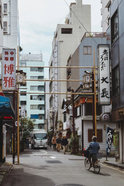 a man riding a bicycle down an old street