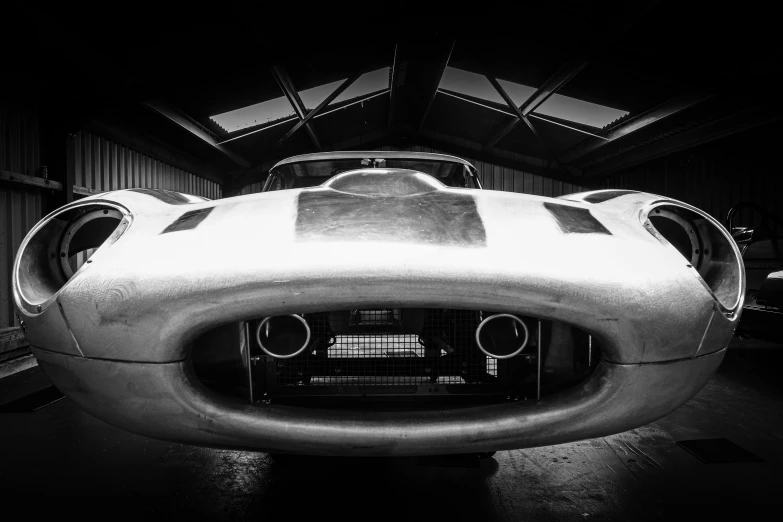 the futuristic car is parked in a barn